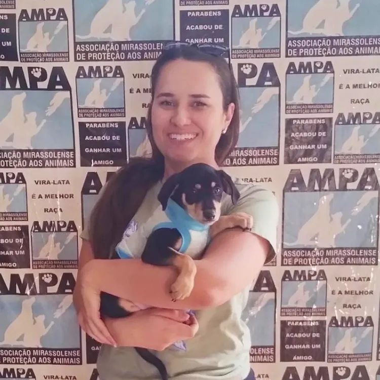 Criança abraçando emocionada seu novo cãozinho recém-adotado na ONG AMPA